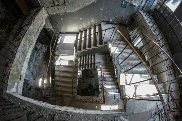 Escaleras en un edificio abandonado, descendiendo. Sensación de vértigo y caída inminente.