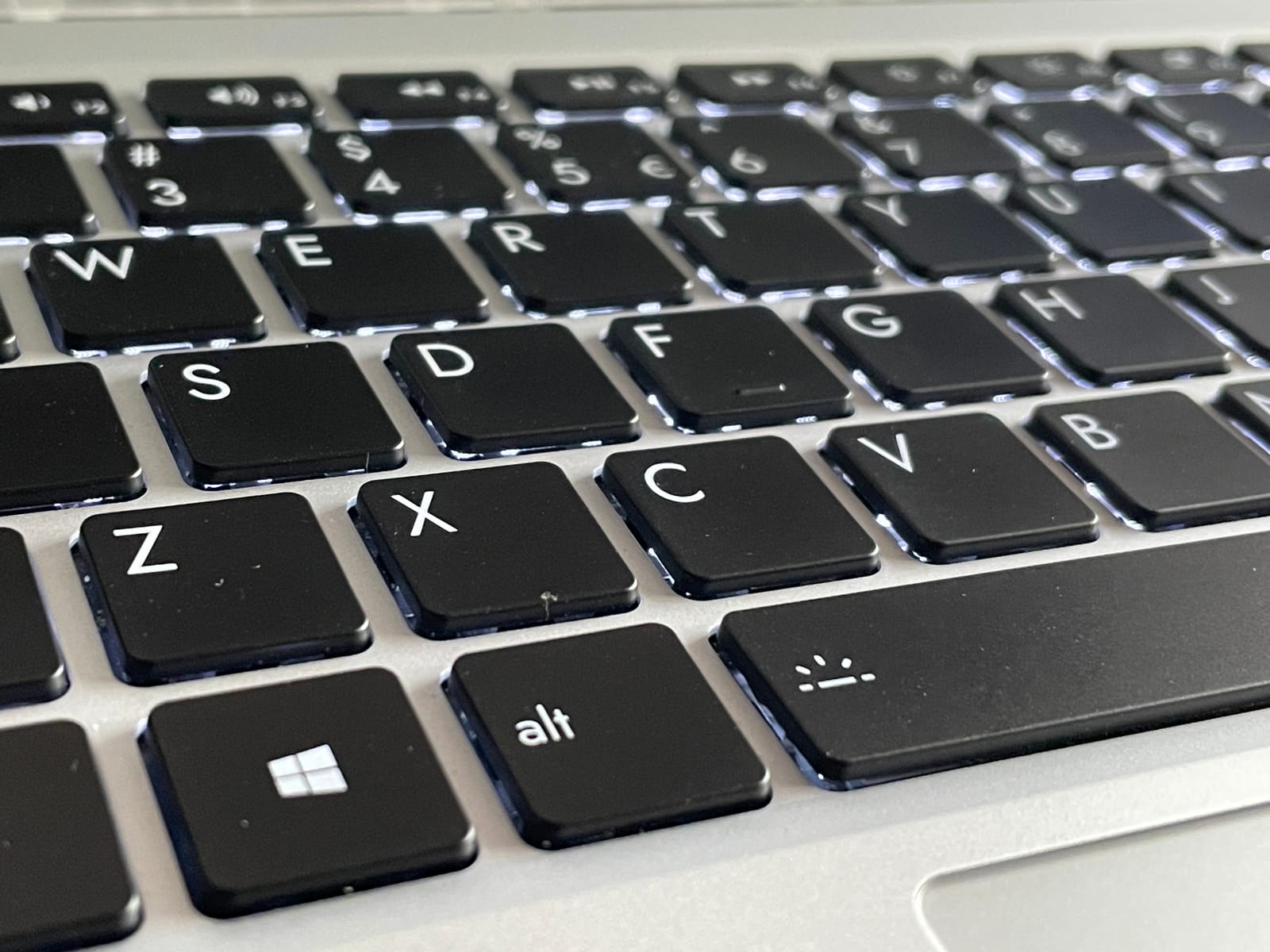 Fotografía del teclado de mi portátil framework. Se puede ver la tecla de Windows en primer término, y la retroiluminación está activada